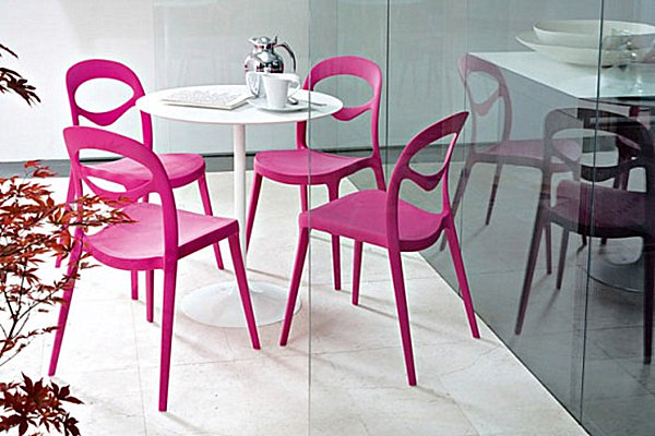 Vivid chairs around a white kitchen table
