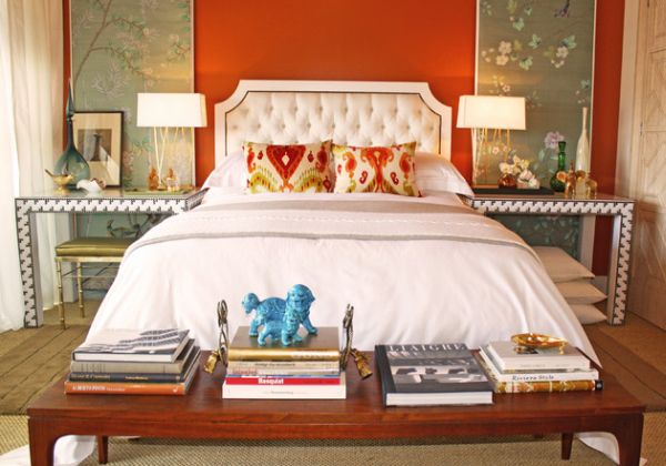 Beautiful tufted headboard stands out in this eclectic bedroom adored by orange hues