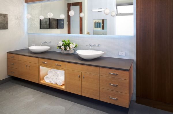 Beautifully back-lit mirror atop a gorgeous floating sink in wood