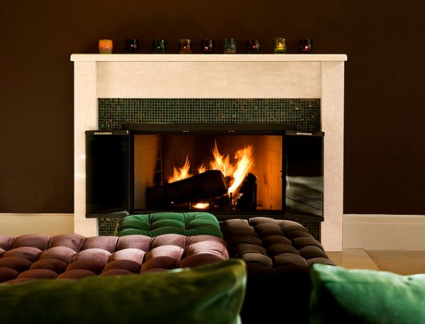 Emerald pillows, a brown sofa and brown walls with a white mantle fireplace