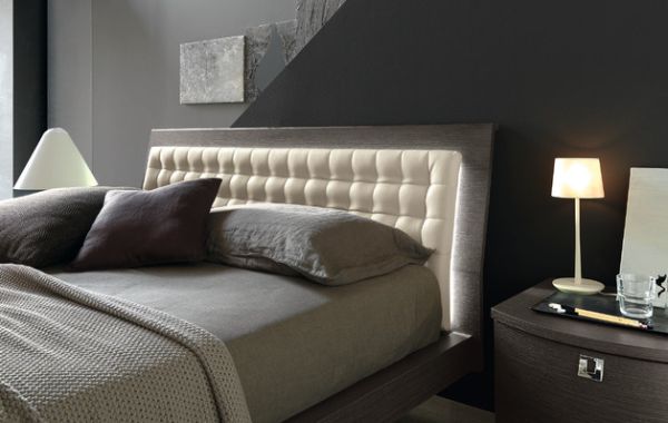 Gentle back light illuminates this slanting tufted headboard for a semi minimalist bedroom