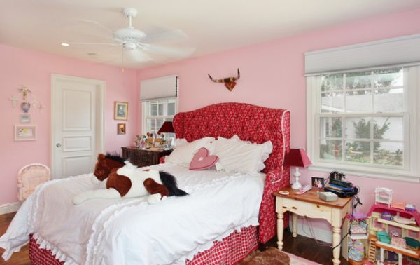Girls’ bedroom with pink upholstered tufted headboard
