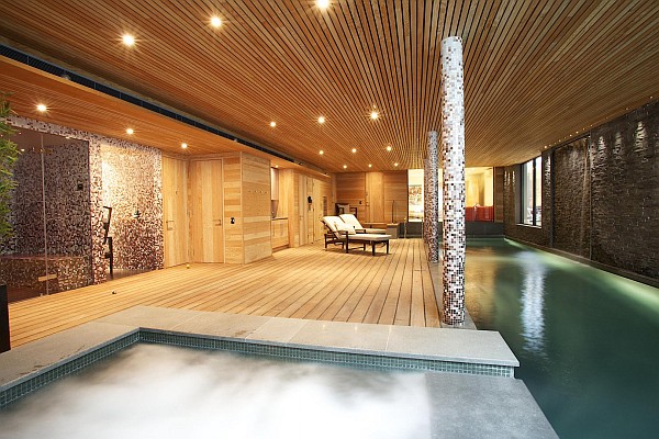 Luxurious home spa with wooden furnished walls and waterworks