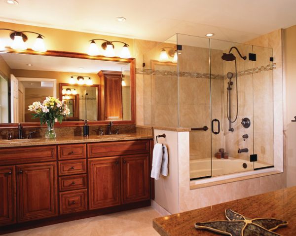 Cherry wood vanity and large glass shower and bathtub enclosure give this bathroom a classic touch