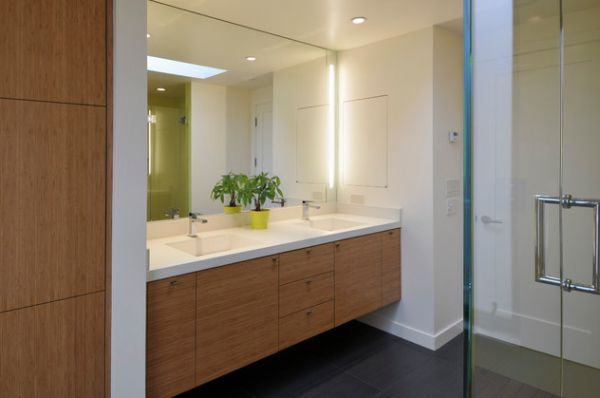 Light cherry wood vanity with white countertop and sidelights on the mirror