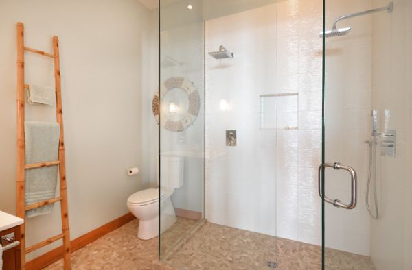 Lovely modern bathroom uses natural tones and glass shower space to create a refreshing feel