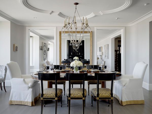 Artistic ceiling design and lovely chandelier give this dining room in neutral tones a classic look