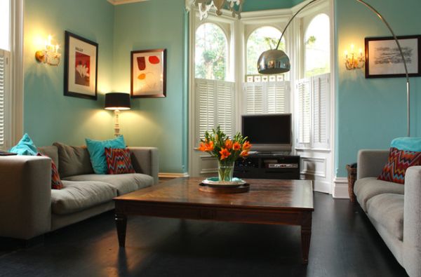 Eclectic blue living space showcases classy use of shutters