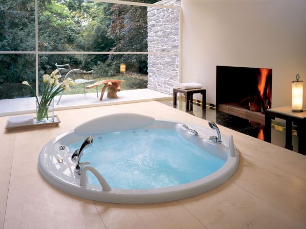 Modern jacuzzi next to a beautiful fireplace