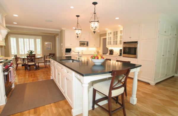 Artistic Hampton Pendant lights above this white kitchen island with dark countertop