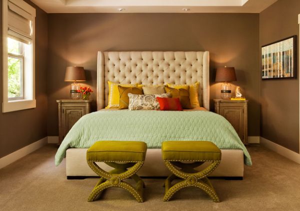 Bedroom in dark hues with a couple of luxurious benches at the foot of the bed