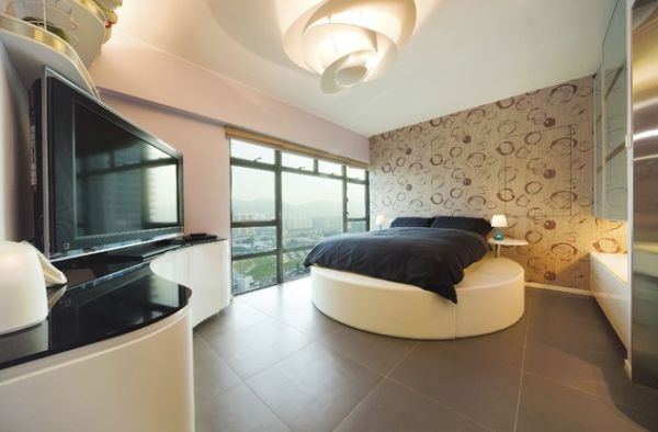 Curved cabinets and innovative lighting compliment the plush round bed