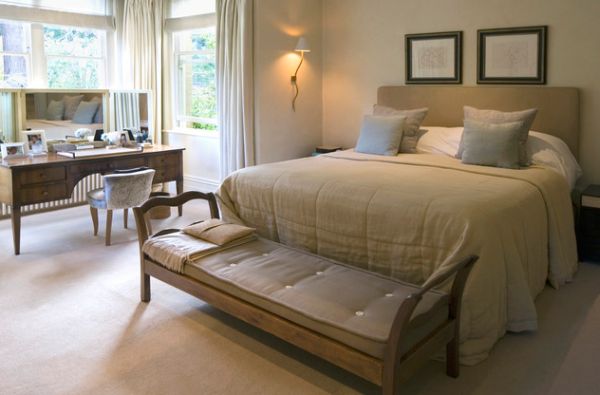 Elegant bedroom with a simple bench at the foor of the bed