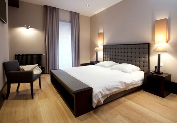 Minimalist bedroom with a sleek bench at the foot of the bed that also provides storage options