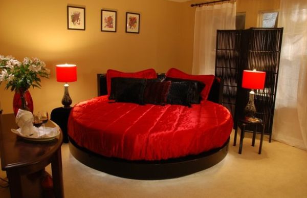 Satin covered round bed in scarlet and black hues for a perfect romantic bedroom theme
