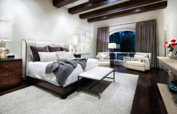 Small tufted bench at the foot of the bed offers a visual contrast to the wooden surroundings