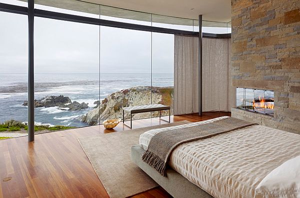 Bedroom with a view of the beach sports a modern fireplace