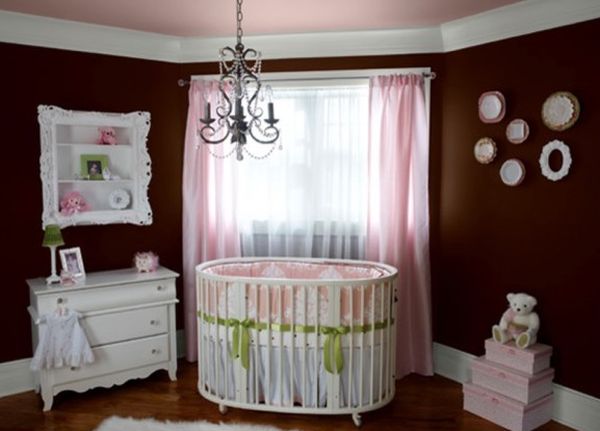 Dark brown walls clubbed with pink accents for a baby girl nursery