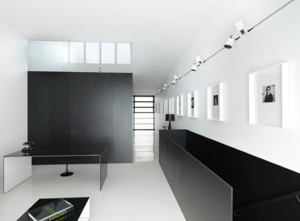 Minimalist interiors with a long gallery wall illuminated by track lighting