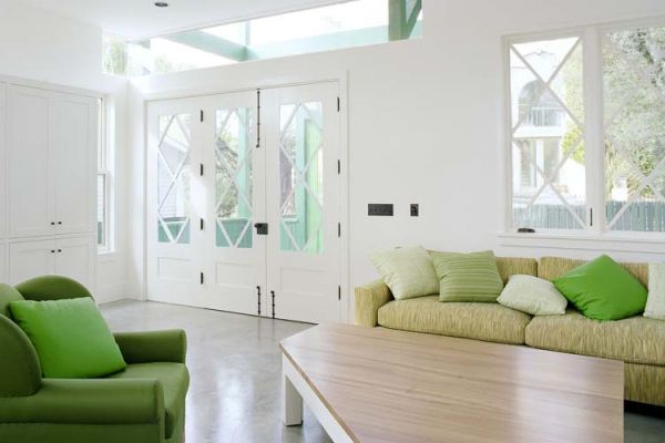 Accent green couch and cushions provide freshness to this living space in neutral hues