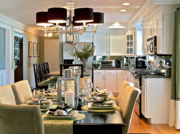 Chandelier with black lampshades above green dining space