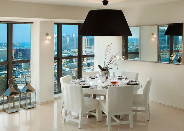 Large pendant light with black lampshade above a pristine white dining space