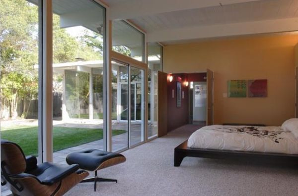 Modern bedroom with extended glass walls and the Eames Lounger in the corner