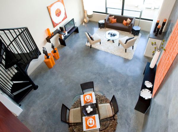 Pop of orange spread throughout the living room with a high ceiling