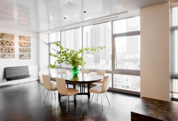 Tall green arrangment on the table in a glass vase becomes the focal point of the space