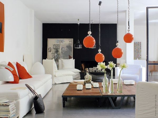 Unique pendant lighting in orange steals the show in this living space