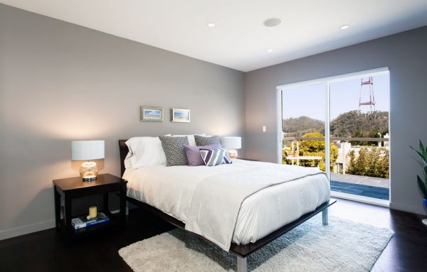 Ample natural ventilation gives the bedroom in light gray an airy appeal