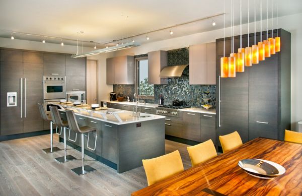 Beautiful lighting and dining area complement the kitchen in gray aptly