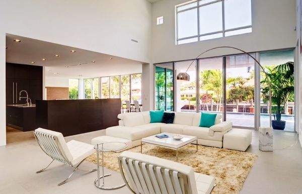 Living space with high ceilings employs the Arco to shed some light on the sectional sofa