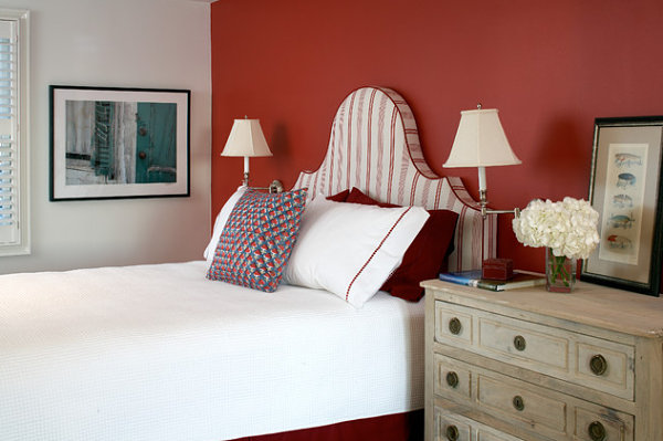 Red accent wall in a crisp bedroom