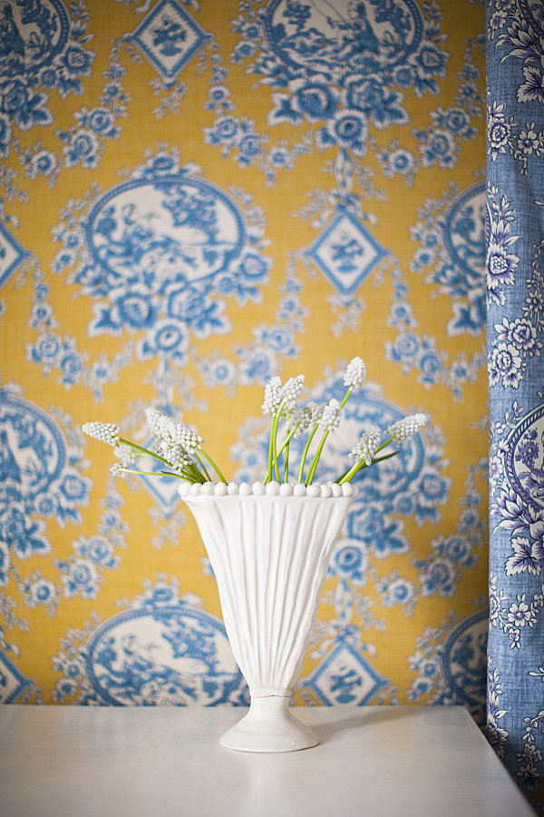 White vase of flowers in a toile bedroom