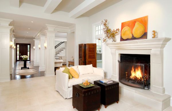 Fruit artwork on top of a fireplace in a white-themed living room.