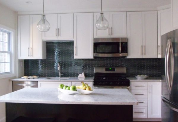 A fruit bowl full of green apples is placed beside another that is holding bananas.