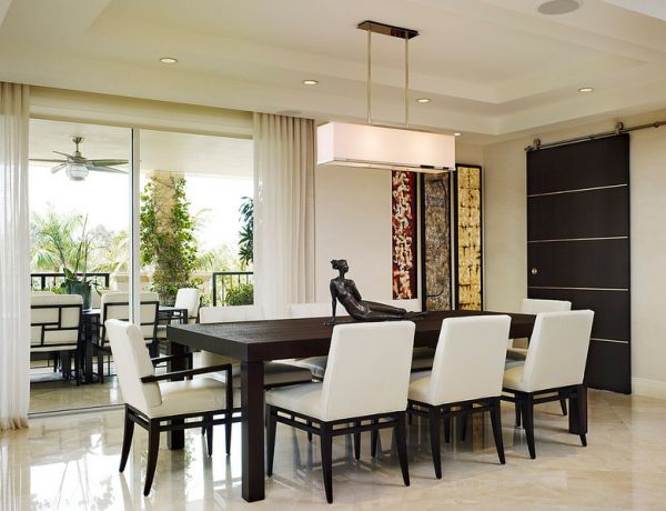 Clean dining area with low profile recessed lighting and large pendant light