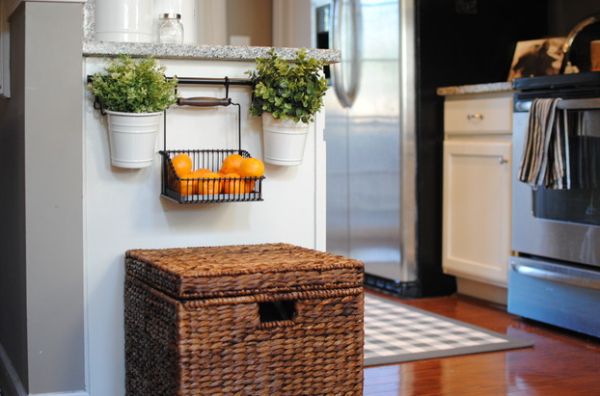 Hanging fruit arrangement full of oranges in a black metal basket.