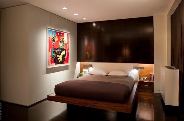 Minimalist bedroom with recessed lights highlighting colorful piece of modern art