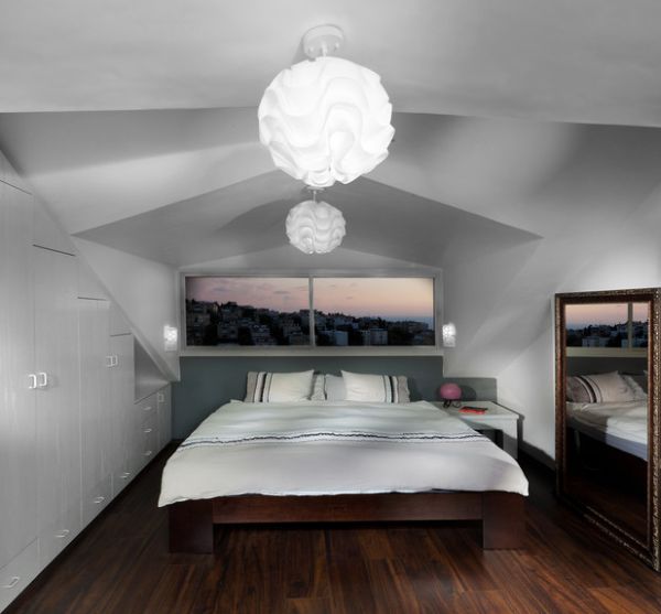 Pendant lights, mirror and the window above the bed bring in a sense of openness