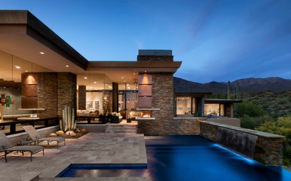 Home's roof extends above the integrated  fireplace next to the pool