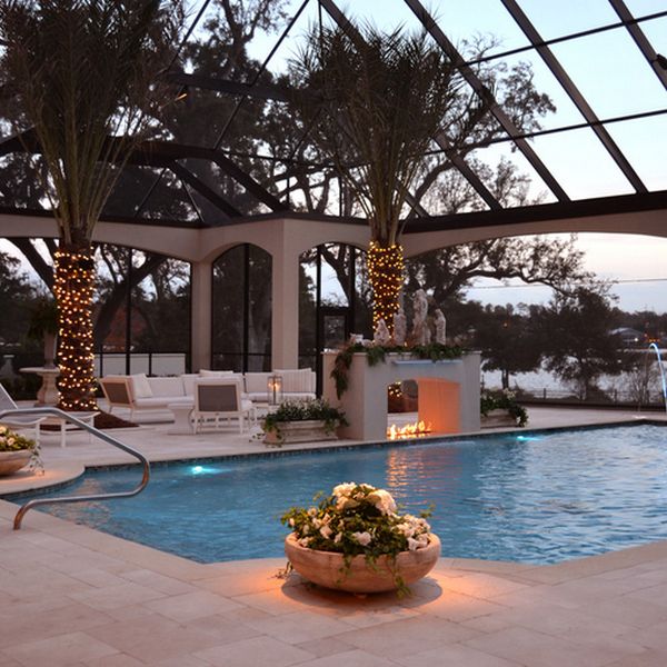 Serene pool with a lovely fireplace next to it