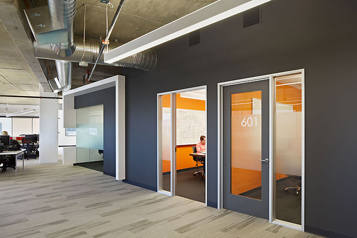 Two bright orange offices add color to the gray wall