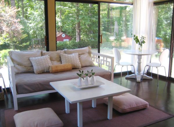 Elegant porch with floor pillows that match the hue of the sofa and the rug