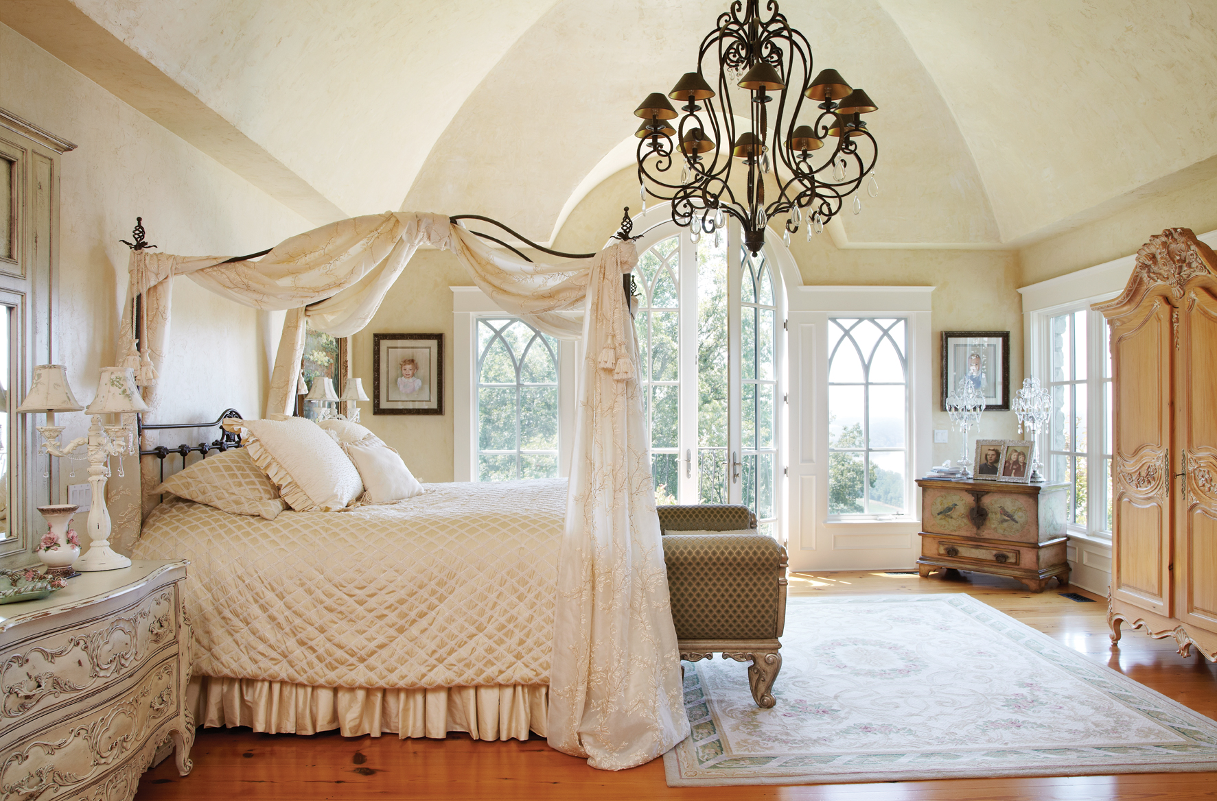 St Louis Homes Mag wrought iron canopy bed with wrought iron chandelier