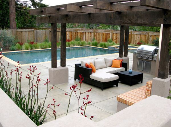 White cushions and deck space offer a lovely contrast to the dark wood of the pergola