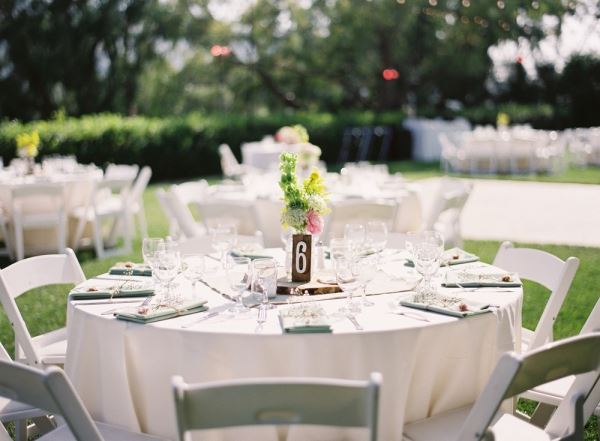 White tables and chairs on a green lawn