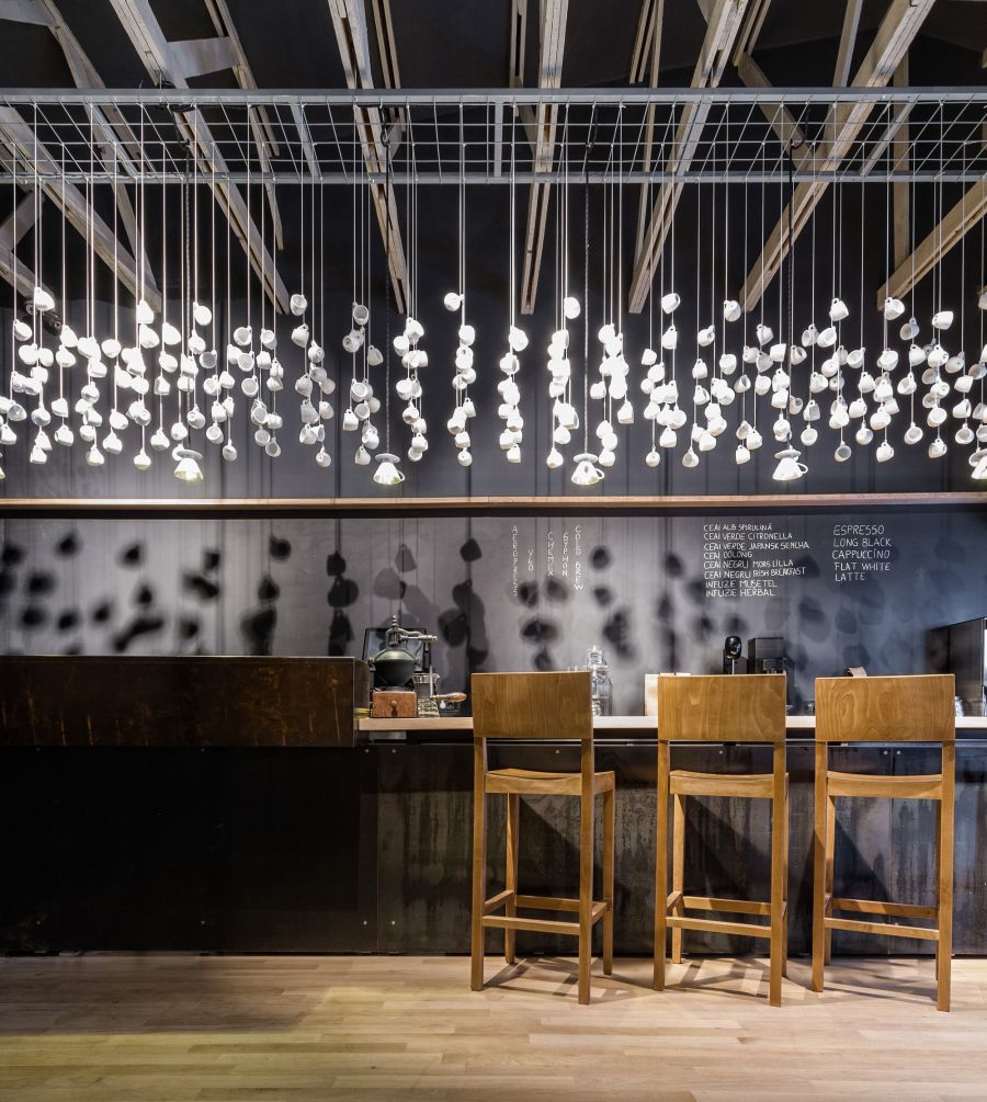 Hanging white cups above the counter at the Origo