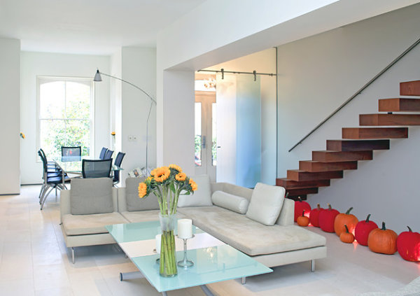 Pumpkins line the floor of a modern home